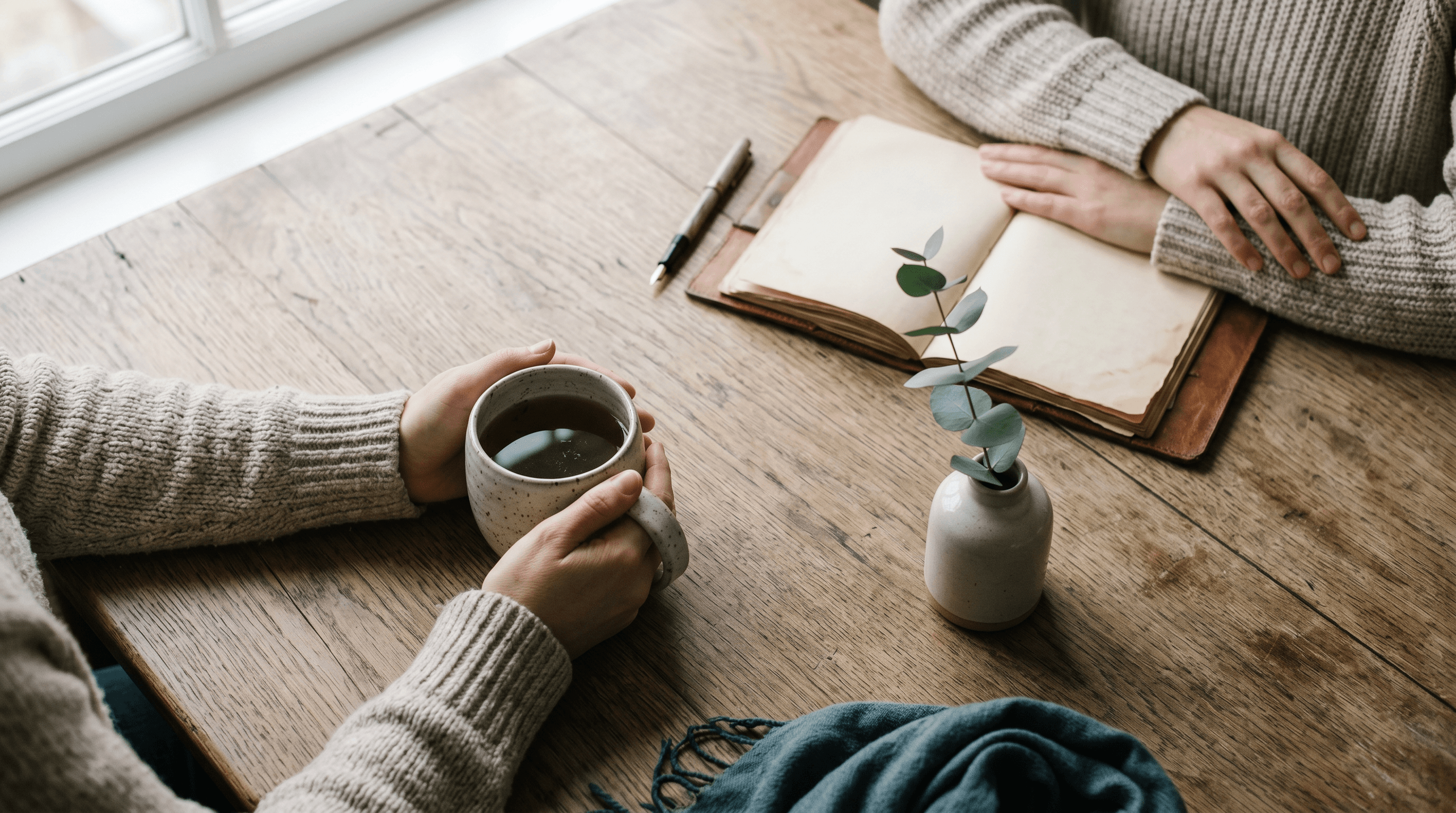 Two people having a quiet conversation over tea and a journal — therapy as a real conversation